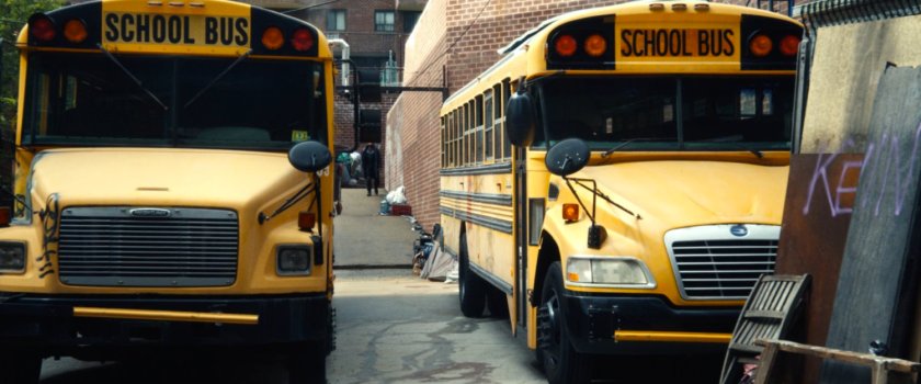 A pair of school buses parked outside Frank's apartment building.
