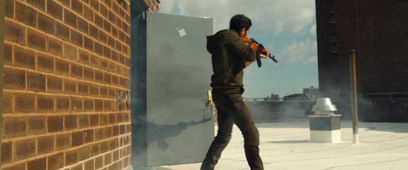 Frank with a gun on top of his apartment building roof.