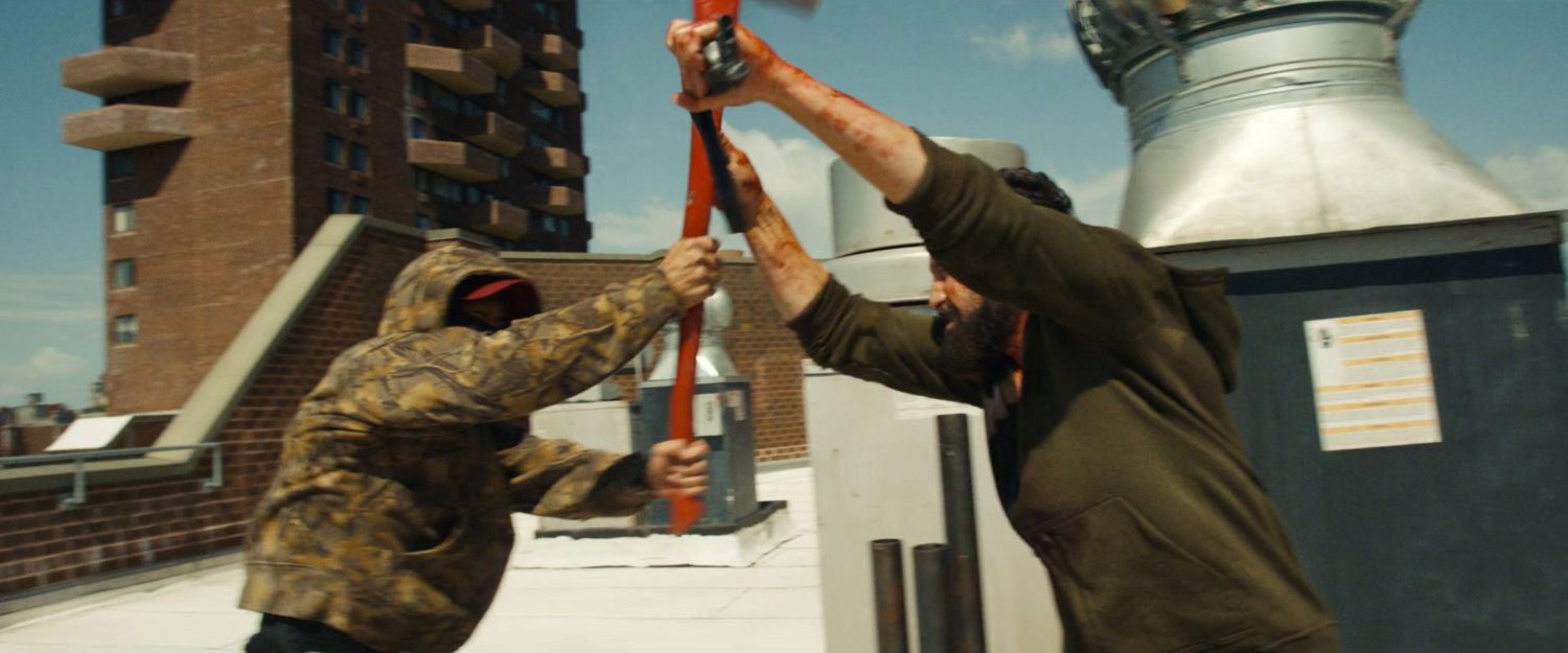 Frank fighting a man with an axe on top of his apartment building roof.