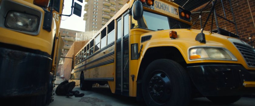 Frank laying between two buses outside his apartment building.