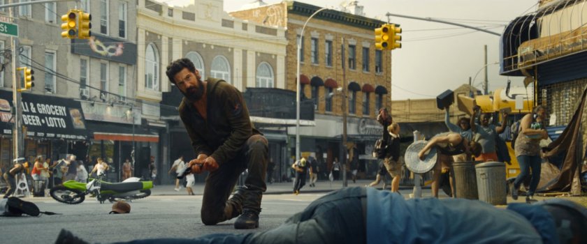 Frank kneeling on the street in Little Sicily.