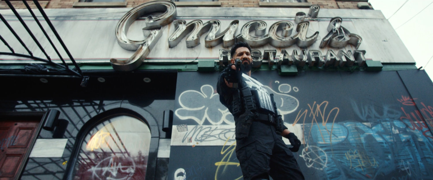 The Punisher taking aim at a skinhead outside Gnucci's Restaurant.