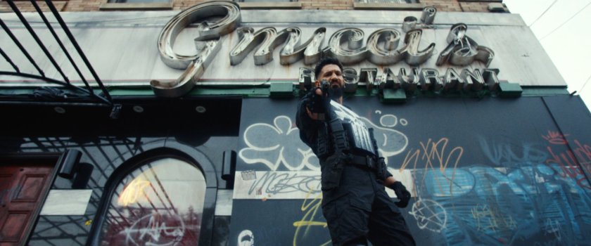 The Punisher taking aim at a skinhead outside Gnucci's Restaurant.