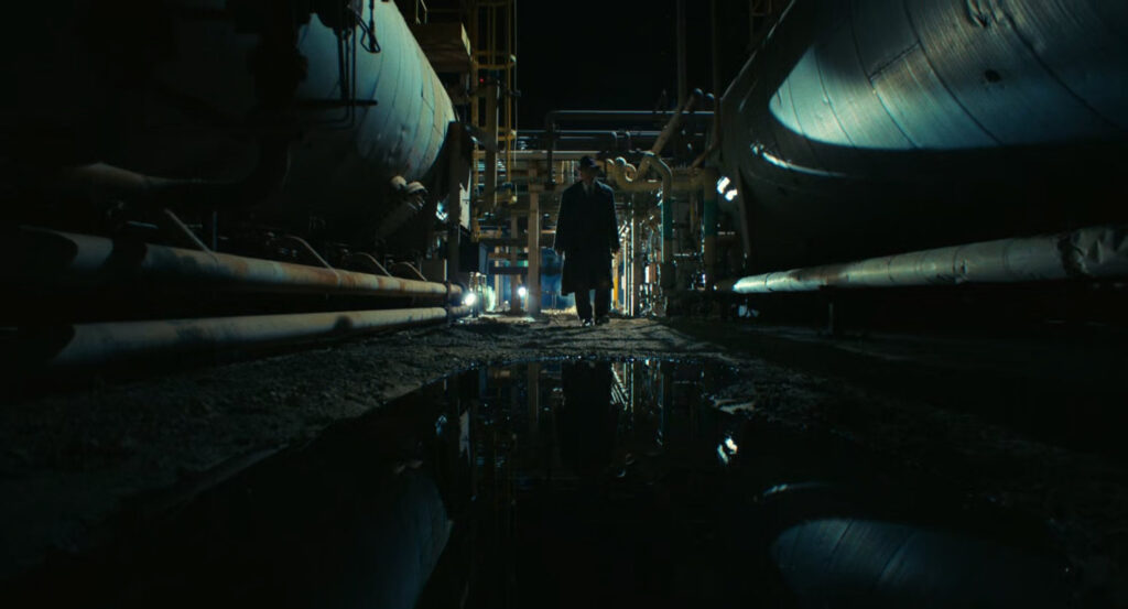 Ben in the shadows of a Standard Oil refinery.