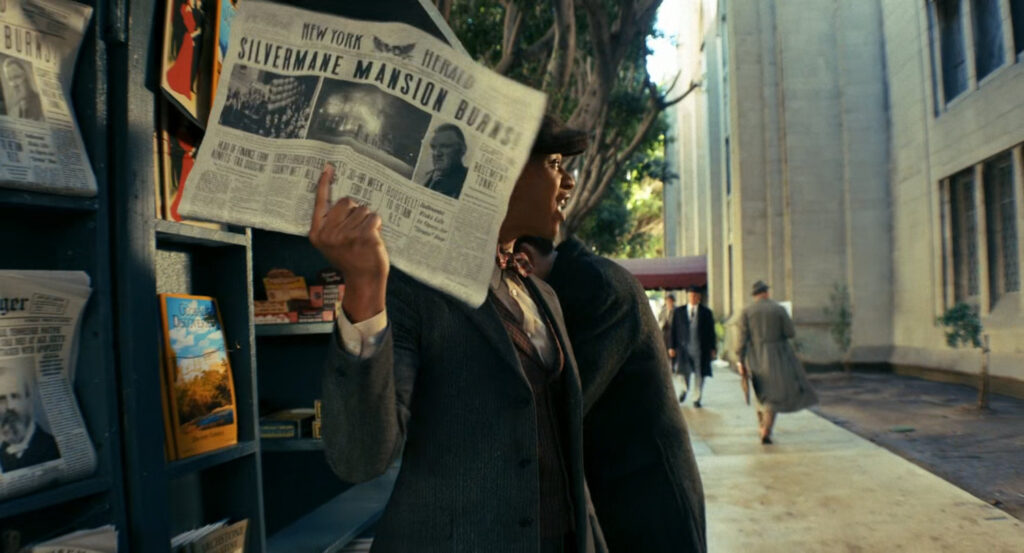 Ben buys a newspaper from a vendor on a sidewalk.