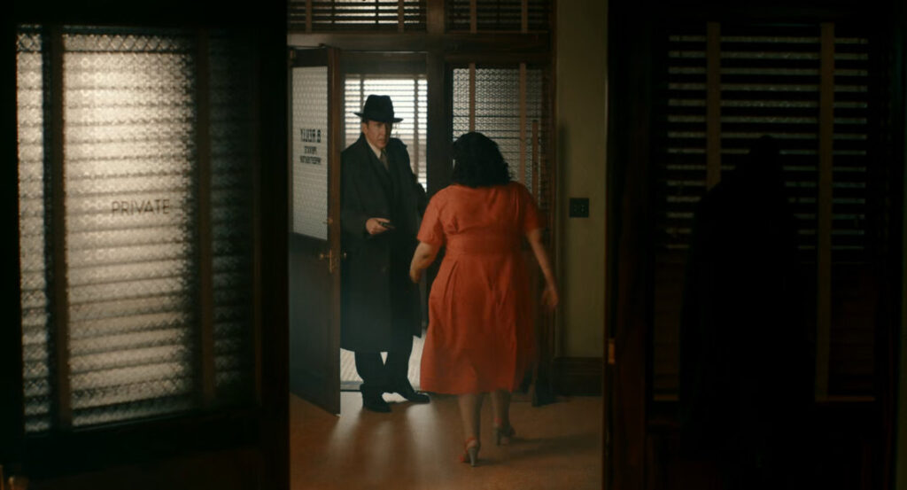 Ben talking to Janet at the front of his office.