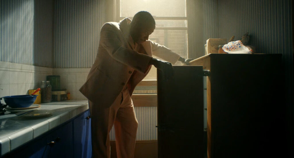 Robbie looks into his icebox in his kitchen.