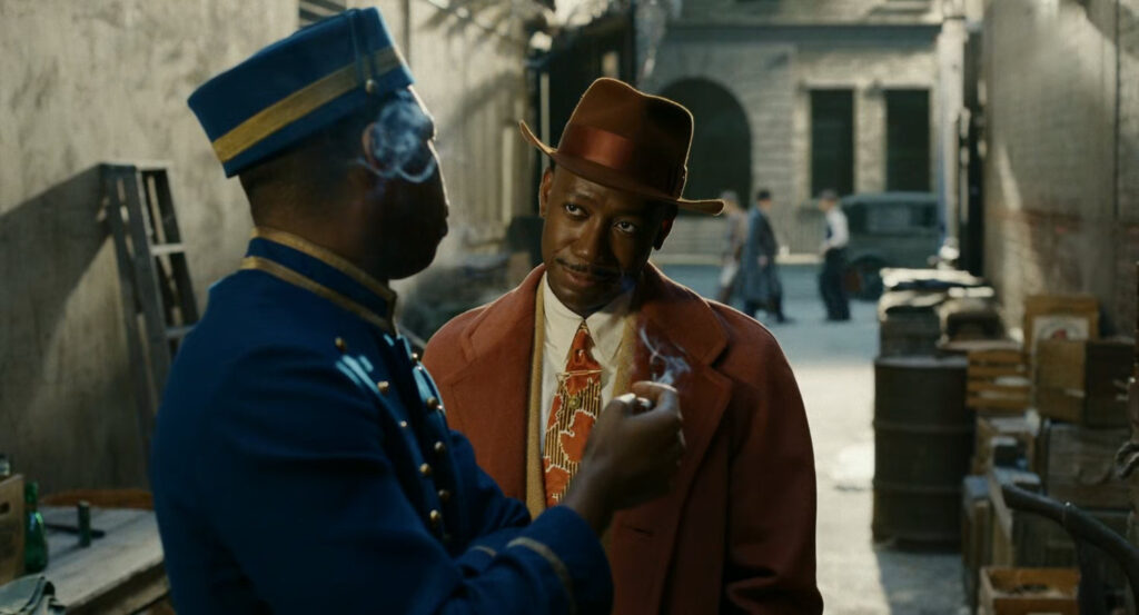 Robbie speaking with a black bellhop in an alley behind the Geoffrey Hotel.