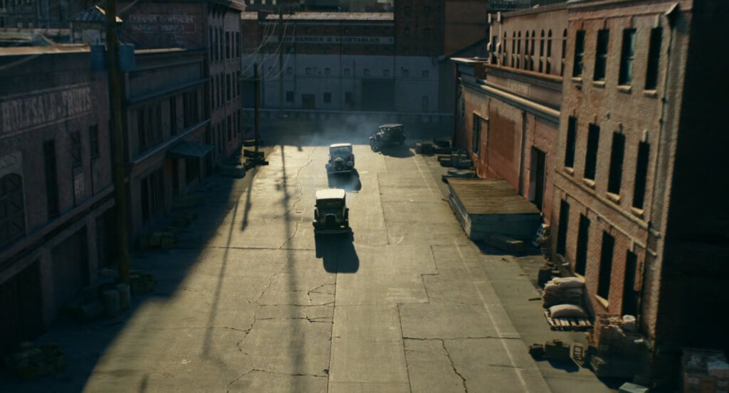 Aerial view of Silvermane's cars driving onto a street at the docks.