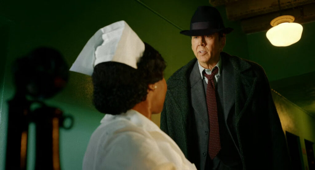 Ben speaking to a nurse in a hospital hallway.