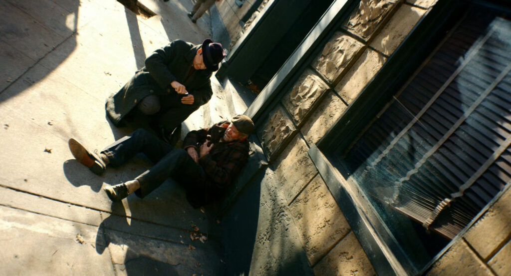 Ben asking a man on the sidewalk where to find Carmedy.