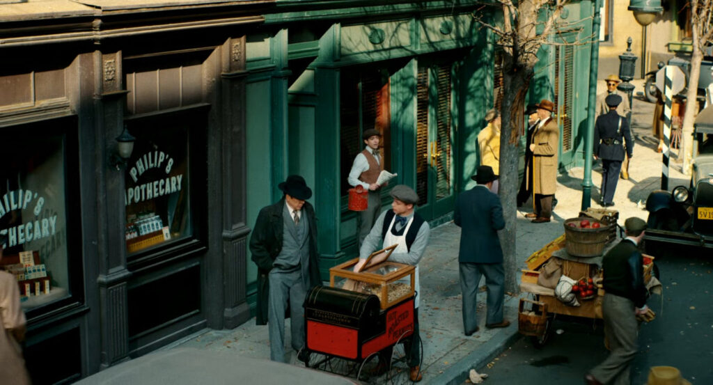 Ben walking past a peanut vendor on the sidewalk.