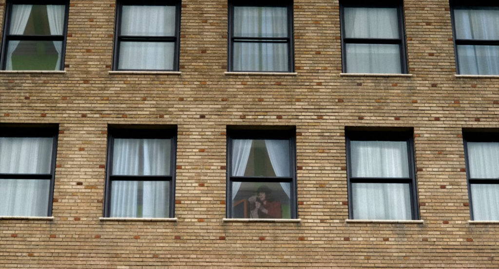 Exterior of the Geoffrey Hotel, showing Vera in her room.