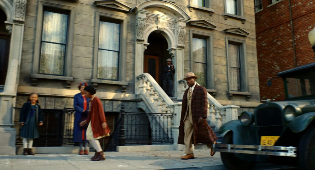 Robbie walking along a street in Harlem.