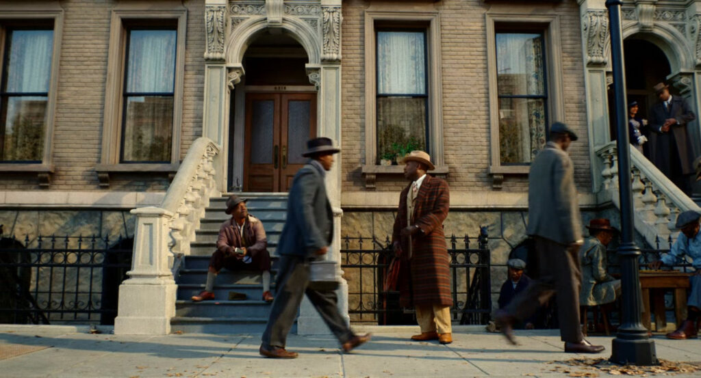 Robbie walking along a street in Harlem.