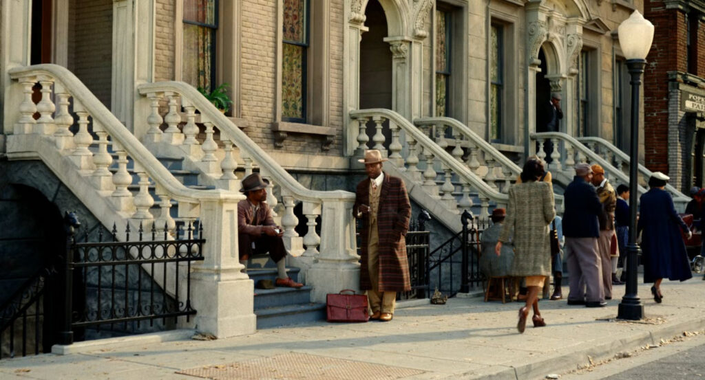 Robbie talking to a man on a stoop in Harlem.