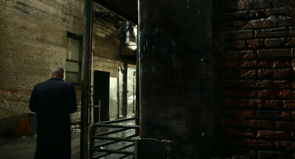 A man walking into a Harlem alley.