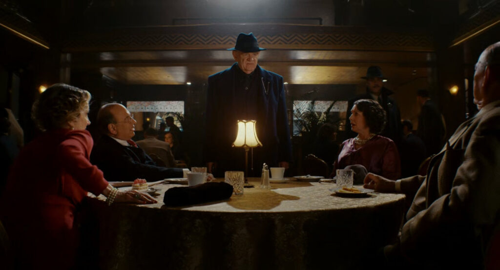 Silvermane speaking with the Mayor, Chief of Police, and their wives at a table in a restaurant club.