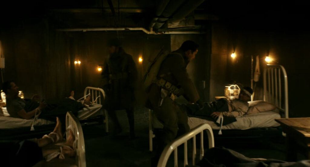 Flashback of Ben helping men in hospital beds during the war in France.