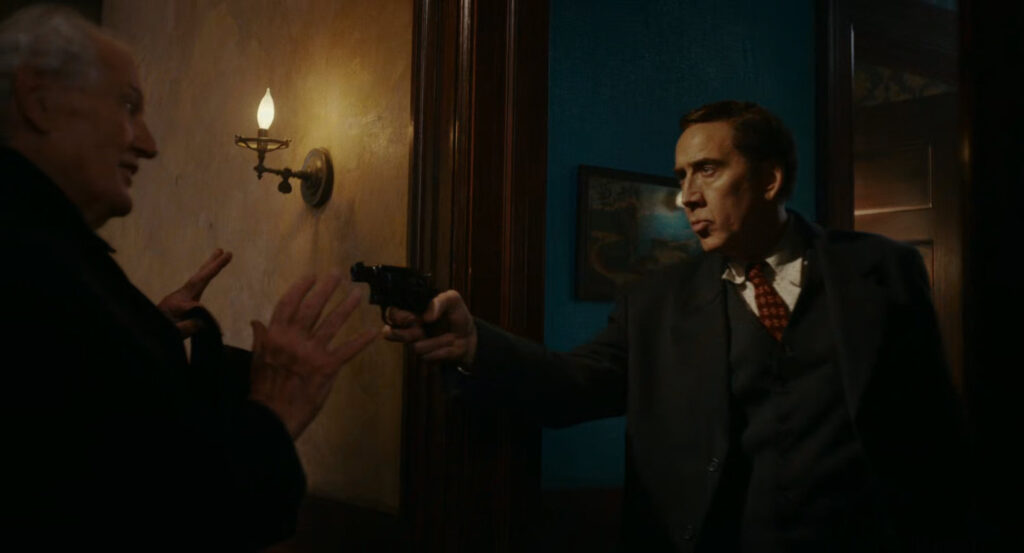 Ben holding a gun on Ogden at his apartment door.