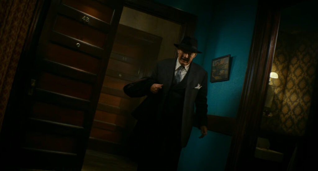 Odgen standing at the front door of Ben's apartment.