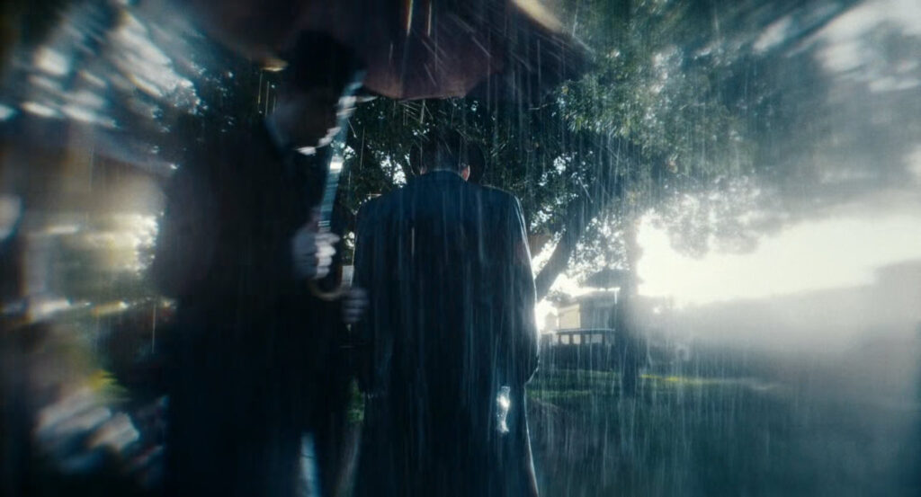 Flashback of Ben at the cemetery on a rainy day.
