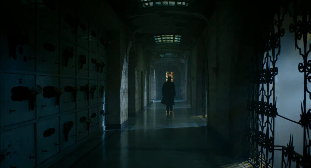 Ben walking along a hallway in a mausoleum in New York.