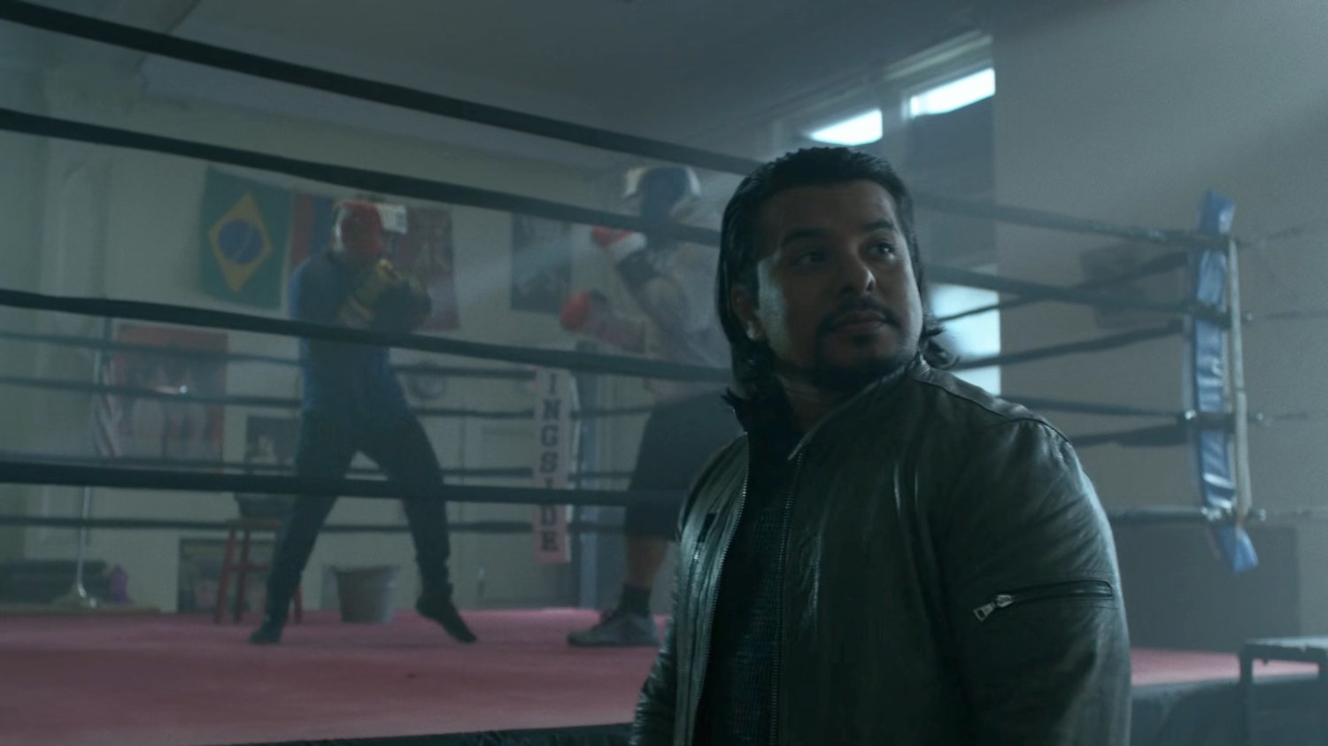 Colon standing in front of two men boxing in Colon's Gym.