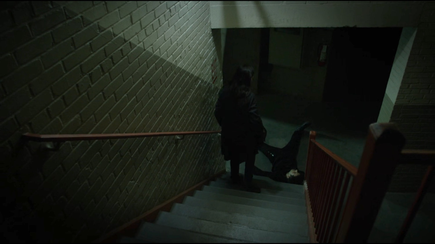 Claire stepping over a downed thug in the basement stairway of Harlem's Paradise.
