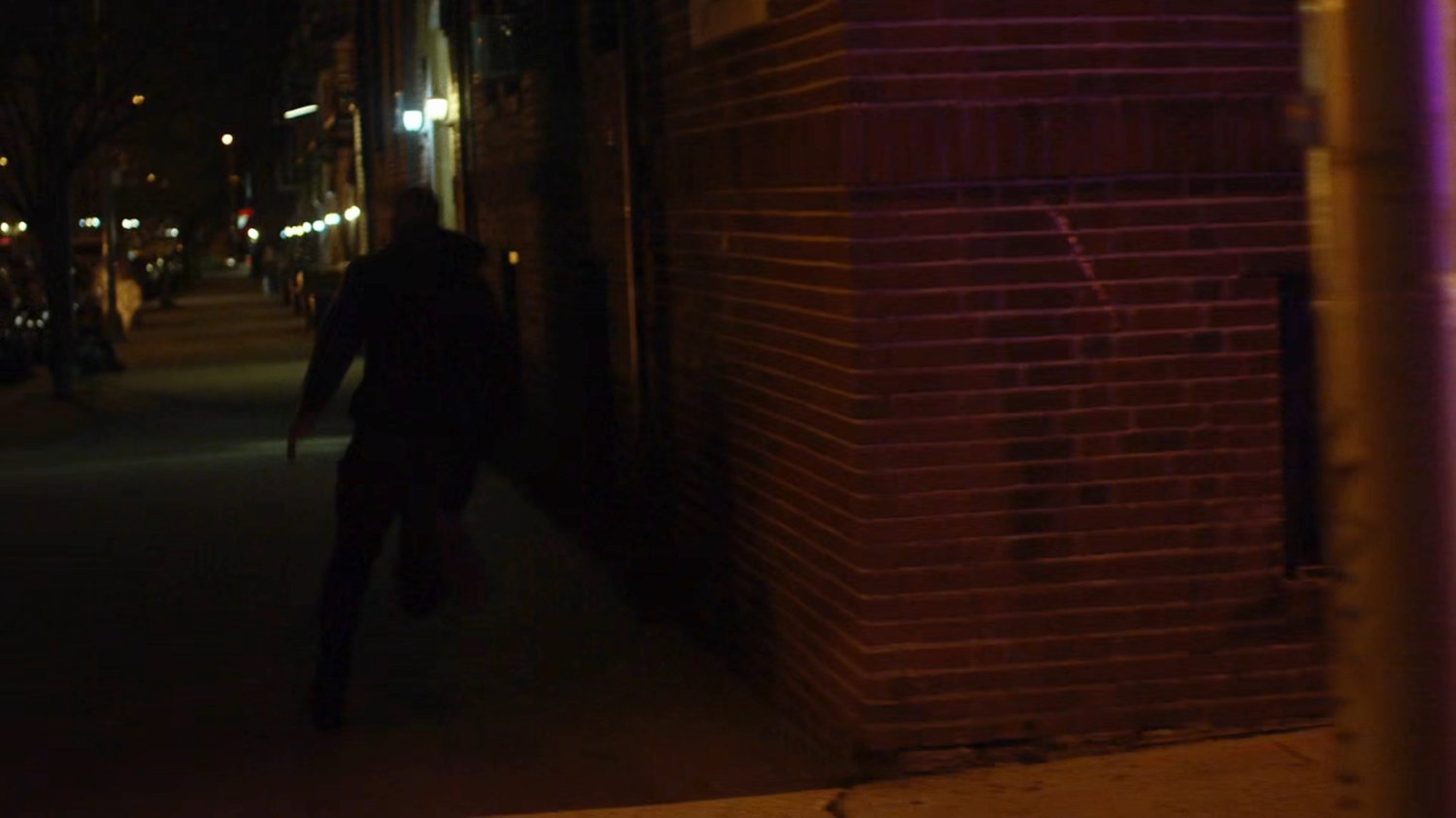 Luke running down a sidewalk away from the officers.