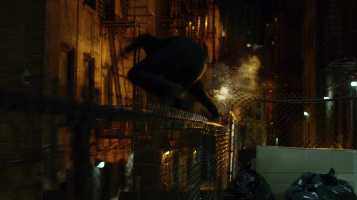 Luke leaping a fence in an alley.