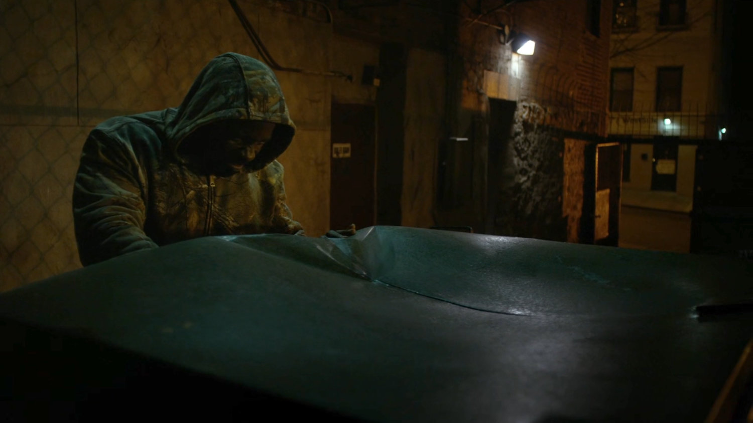 Luke puts Turk in a dumpster in a dark alley.