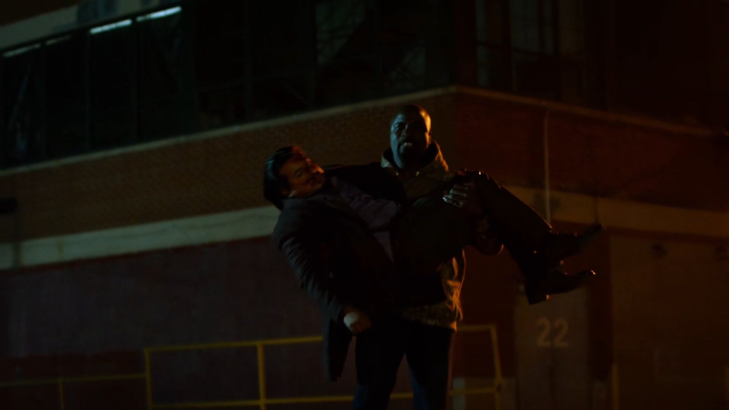 Luke carrying Colon outside Diamondback's arms warehouse.