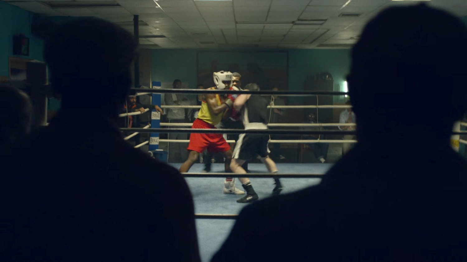 Young Carl and another teenager sparring in a boxing gym.